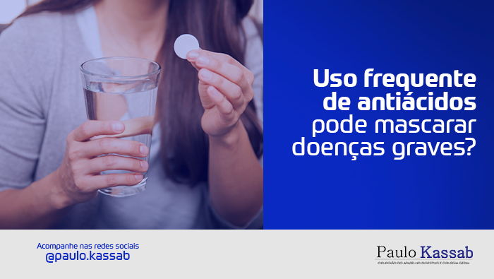 Pessoa segura um comprimido branco efervescente ao lado de um copo com água, sugerindo o uso de medicamento para alívio de desconforto digestivo.