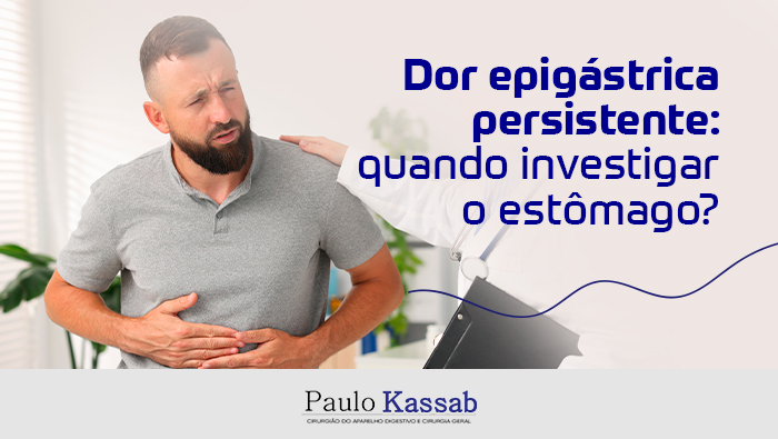Dor epigástrica persistente: quando investigar o estômago? 1 Paciente sentado com a mão no abdômen em sinal de dor enquanto médica o examina e oferece orientação em consultório.